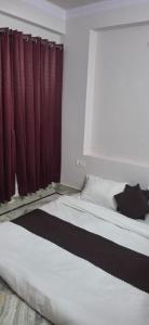 een bed in een kamer met rode gordijnen bij Raghuvar Vilas in Varanasi