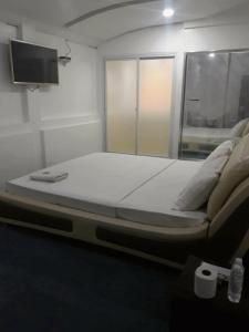 a large bed in a room with a flat screen tv at 999 Hotel in Angeles