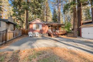a cabin in the woods with a fence at Diana's Cabin by Tahoe Getaways - Pet-Friendly 2BR in Kings Beach w Backyard & Walk to Lake! in Wood Vista