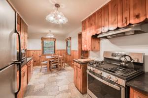 a kitchen with wooden cabinets and a stove top oven at Diana's Cabin by Tahoe Getaways - Pet-Friendly 2BR in Kings Beach w Backyard & Walk to Lake! in Wood Vista +15 photos