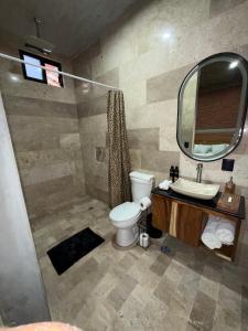 a bathroom with a toilet and a sink and a mirror at Casa Don Tacho in Cedro
