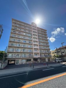 a large apartment building with the sun shining on it at プリンスプラージュ沖縄301 in Onna