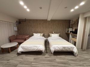 a hotel room with two beds and a couch at プリンスプラージュ沖縄301 in Onna +40 photos