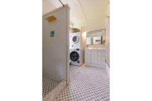 a laundry room with a washer and a washing machine at Pippis a Classic Beach House in Seal Rocks +16 photos