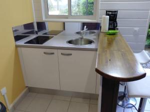a small kitchen with a sink and a counter at Bungalow Dumonter in Baie-Mahault