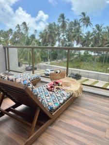 a bed on a balcony with a view of the ocean at Villa Naluri - Casa Auati - Apart 2 Quartos -Vista Mar in Japaratinga