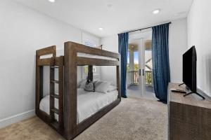 a bedroom with a bunk bed and a flat screen tv at It's a Shore Thing in Inlet Beach +81 photos