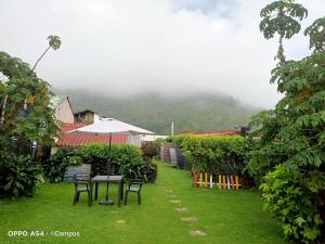 a table with an umbrella and chairs in a yard at Bahareque hospedaje in Monguí