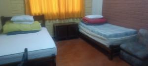 a room with two beds and a couch and a window at Cozy Rural House in Apata - Jauja 