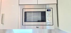 a microwave oven hanging on a kitchen cabinet at La Cámara de El Cristo in Oviedo