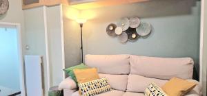 a living room with a couch and hats on the wall at La Cámara de El Cristo in Oviedo