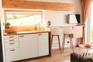 a kitchen with white cabinets and a sink and a window at M&D Appartments in Valtice