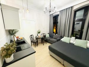 a living room with a bed and a dining room at Apartamenty PREMIUM Rynek 21 in Toruń