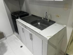 a small kitchen with a sink and a stove at Playa Los Cocos Apat 2 y 3 in Santa Marta +60 photos