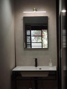 ein Badezimmer mit Waschbecken und Spiegel in der Unterkunft BoBuchi in Ichihara
