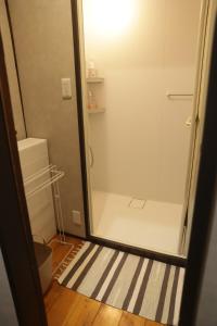 een douche met een glazen deur in een badkamer bij BoBuchi in Ichihara +25 foto's