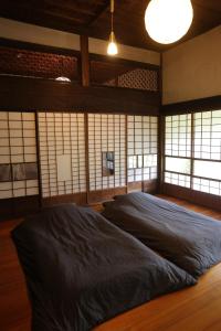 een slaapkamer met een groot bed in een kamer met ramen bij BoBuchi in Ichihara