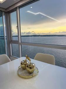 a white table with two gold tea cups on it at Apartamento en Palmetto sunset frente al mar piso 20 in Cartagena de Indias +21 photos