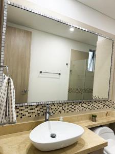 a bathroom with a sink and a large mirror at Apartamento en Palmetto sunset frente al mar piso 20 in Cartagena de Indias