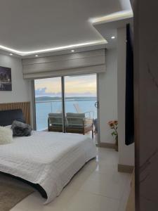a bedroom with a bed and a view of the ocean at Apartamento en Palmetto sunset frente al mar piso 20 in Cartagena de Indias