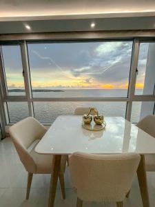 a white table and chairs with a view of the ocean at Apartamento en Palmetto sunset frente al mar piso 20 in Cartagena de Indias