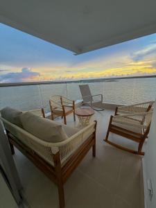 a boat with a bed and chairs on the water at Apartamento en Palmetto sunset frente al mar piso 20 in Cartagena de Indias