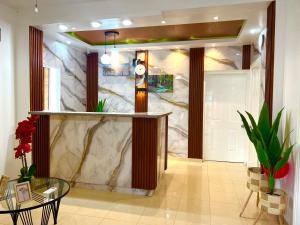 a lobby with a marble wall with a bar in it at Luxury GuestHouse Suites in Cap-Haïtien