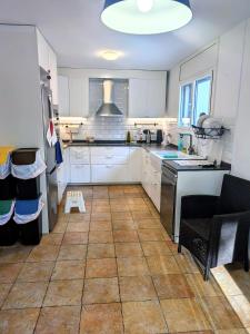 a kitchen with white cabinets and a tile floor at Can Altaba in Maçanet de la Selva