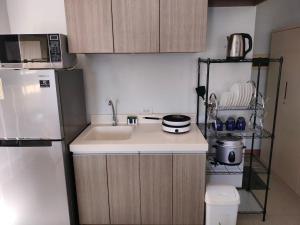 a small kitchen with a sink and a refrigerator at Penthouse A Near IT Park in Cebu City +9 photos