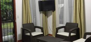 ein Zimmer mit drei Stühlen und einem Fernseher an der Wand in der Unterkunft Apto Cielo Azul in Manuel Antonio