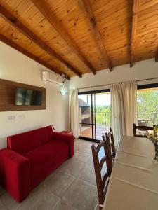a living room with a red couch and a table at Refugio de las Nubes in Las Rabonas