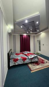 a bedroom with a bed with red flowers on it at غرف نوم في الخوض in Ḩayl Āl ‘Umayr