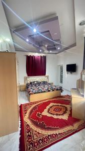 a bedroom with a bed and a red rug at غرف نوم في الخوض in Ḩayl Āl ‘Umayr