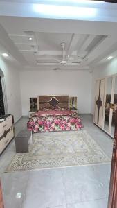a bedroom with a large bed with pink flowers at غرف نوم في الخوض in Ḩayl Āl ‘Umayr