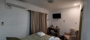 a hotel room with a bed and a chair and a television at GR Hotel in La Rioja