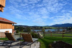 Jägar Chalet - Feriendorf Via Claudia Haus 73 في Illach: كرسيين على فناء مطل على بحيرة