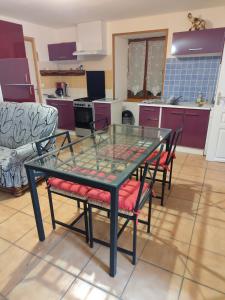 a glass table and chairs in a kitchen at F1 plain-pied in Montjaux