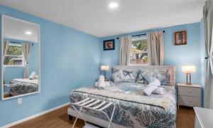 a blue bedroom with a bed and a mirror at Peaceful Family Getaway in Venice in Venice