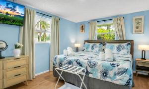 a bedroom with a bed with blue walls and windows at Peaceful Family Getaway in Venice in Venice