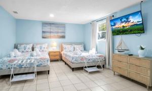 a bedroom with two beds and a tv on the wall at Peaceful Family Getaway in Venice in Venice +61 photos