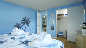 a blue bedroom with a bed with towels on it at Peaceful Family Getaway in Venice in Venice