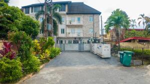 a driveway in front of a house with a gate at Kings Apartment Ikeja in Ikeja