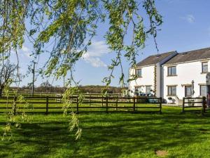 ein Zaun vor einem Haus und einem Feld in der Unterkunft Mallard at Spring Head Farm in Bolton by Bowland