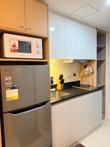 a kitchen with a refrigerator and a microwave at Cliffiens Cozy Space in Sampong