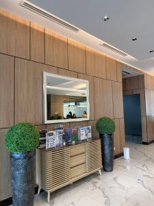a hotel lobby with a mirror and two plants at Cliffiens Cozy Space in Sampong +36 photos