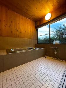 a bathroom with a tub and a sink and a window at Gubo Satoyama Suite Lodge & Camp - Vacation STAY 39508v in Katsuura