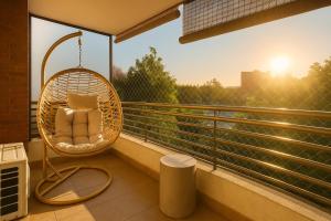 Una silla de ratán en un balcón al amanecer en Departamento Nuevo en Ñuñoa full equipado, en Santiago