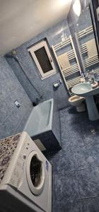a bathroom with a washing machine and a sink at Urban Holiday Retreat in Craiova