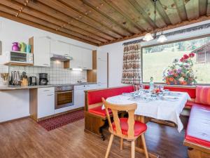 a kitchen and dining room with a table and red chairs at Schwoichbauer II in Saalbach Hinterglemm