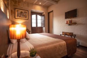 1 dormitorio con 1 cama con lámpara. en Acolpacha Tambo Boutique, en Arequipa